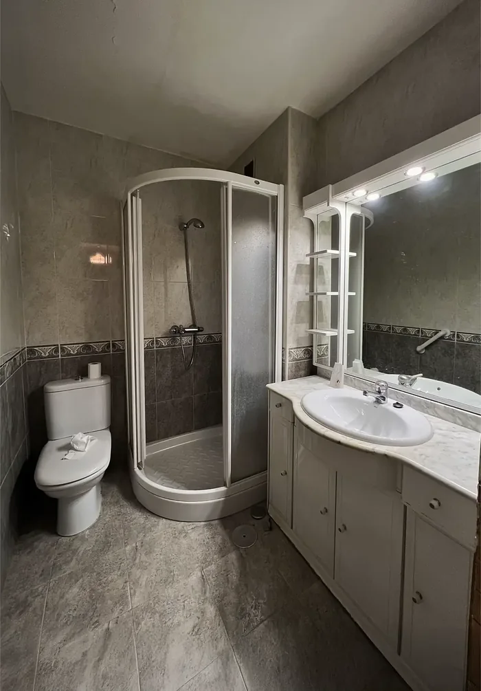 Baño antes de la reforma, con mampara redonda antigua