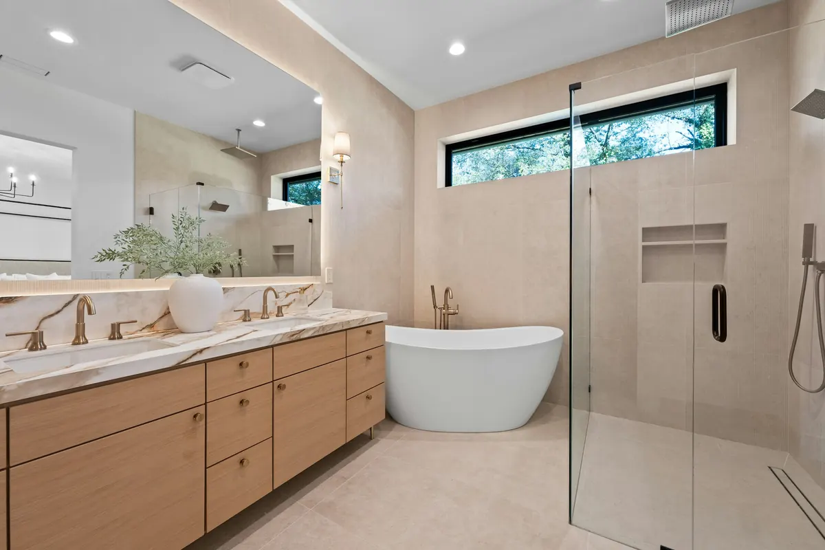Baño reformado con mueble de madera, bañera exenta y ducha de cristal