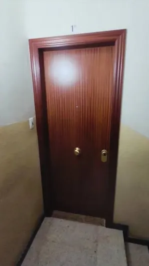 Puerta de entrada de madera instalada en un rellano