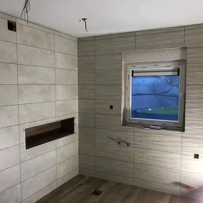 Baño alicatado con gran formato y hornacina durante la reforma
