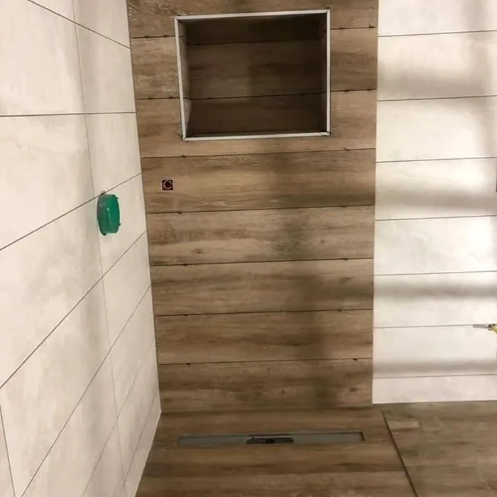 Baño alicatado con porcelánico efecto madera y hornacina