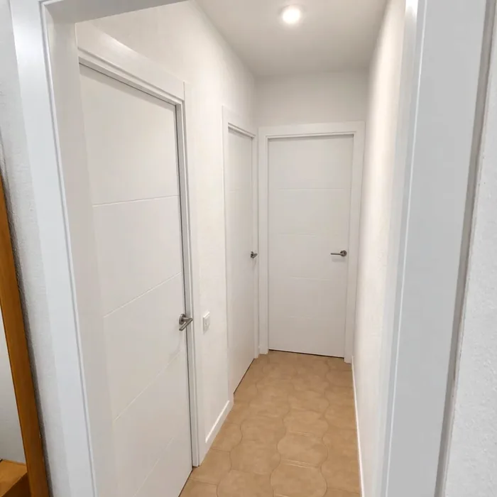 Pasillo con puertas interiores lacadas en blanco instaladas